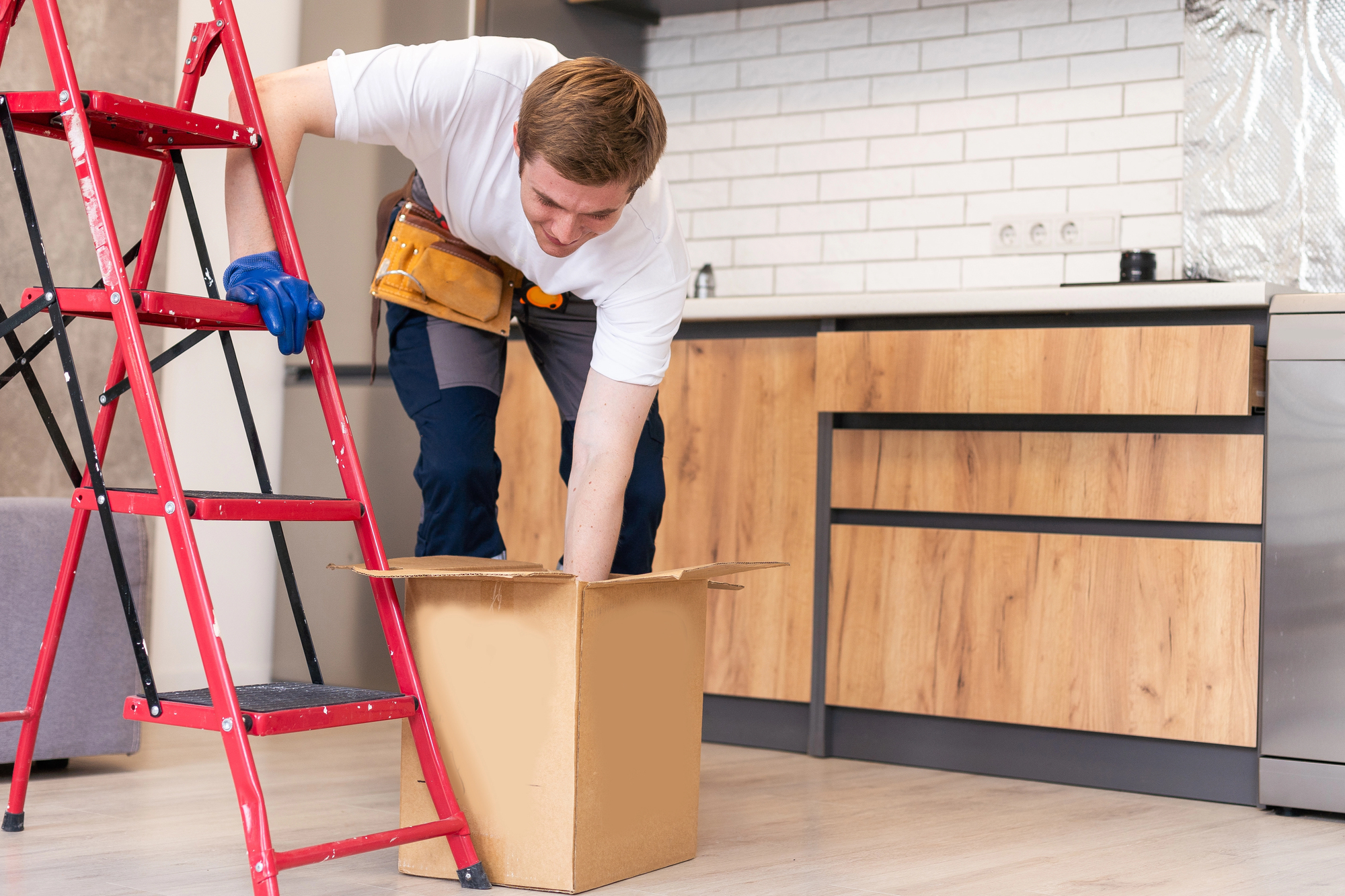 Hombre al lado de escaleras y una caja